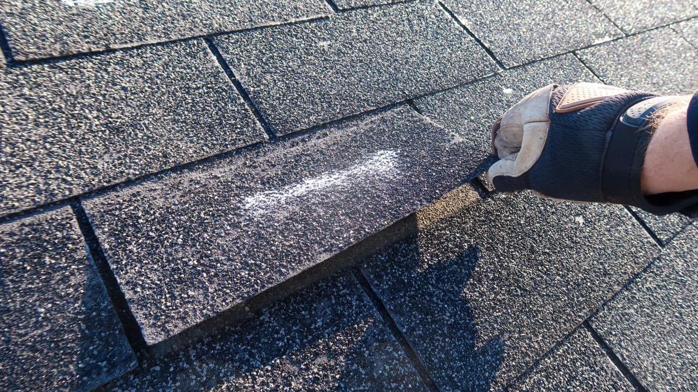 Close-up of asphalt shingle showing granule loss from UV exposure