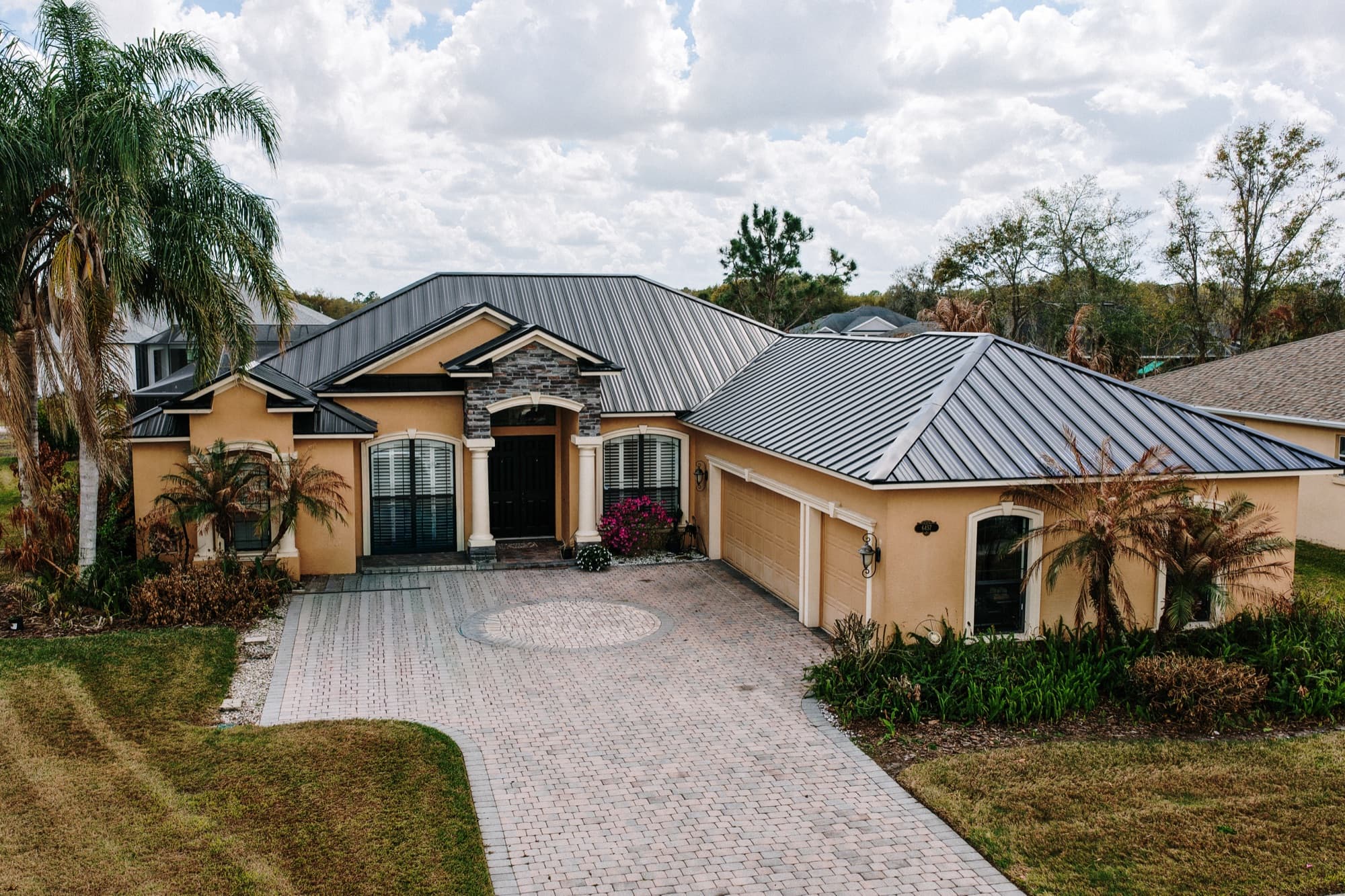 Tan standing-seam metal roof installation on a Central Florida home