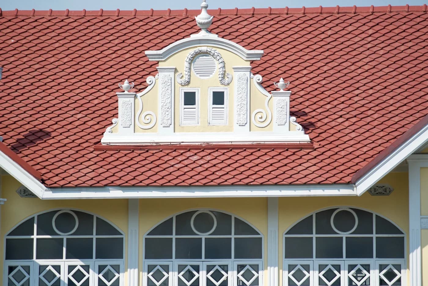Ornate Mediterranean building with a red S-tile roof and decorative dormer in Tampa