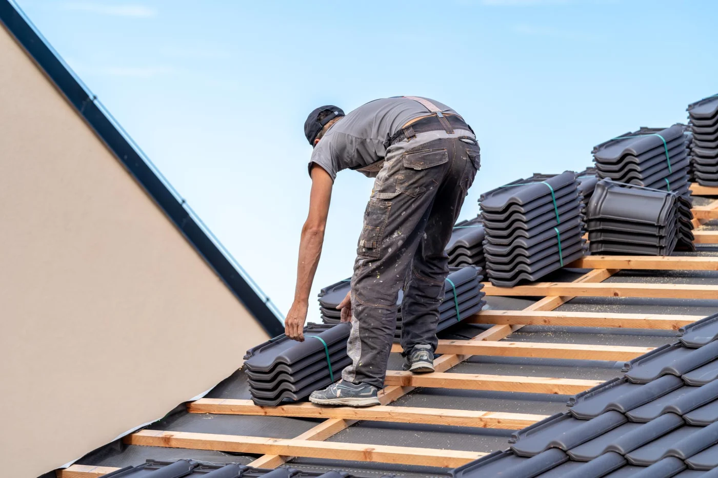 Roofer installing a roof on a new construction home