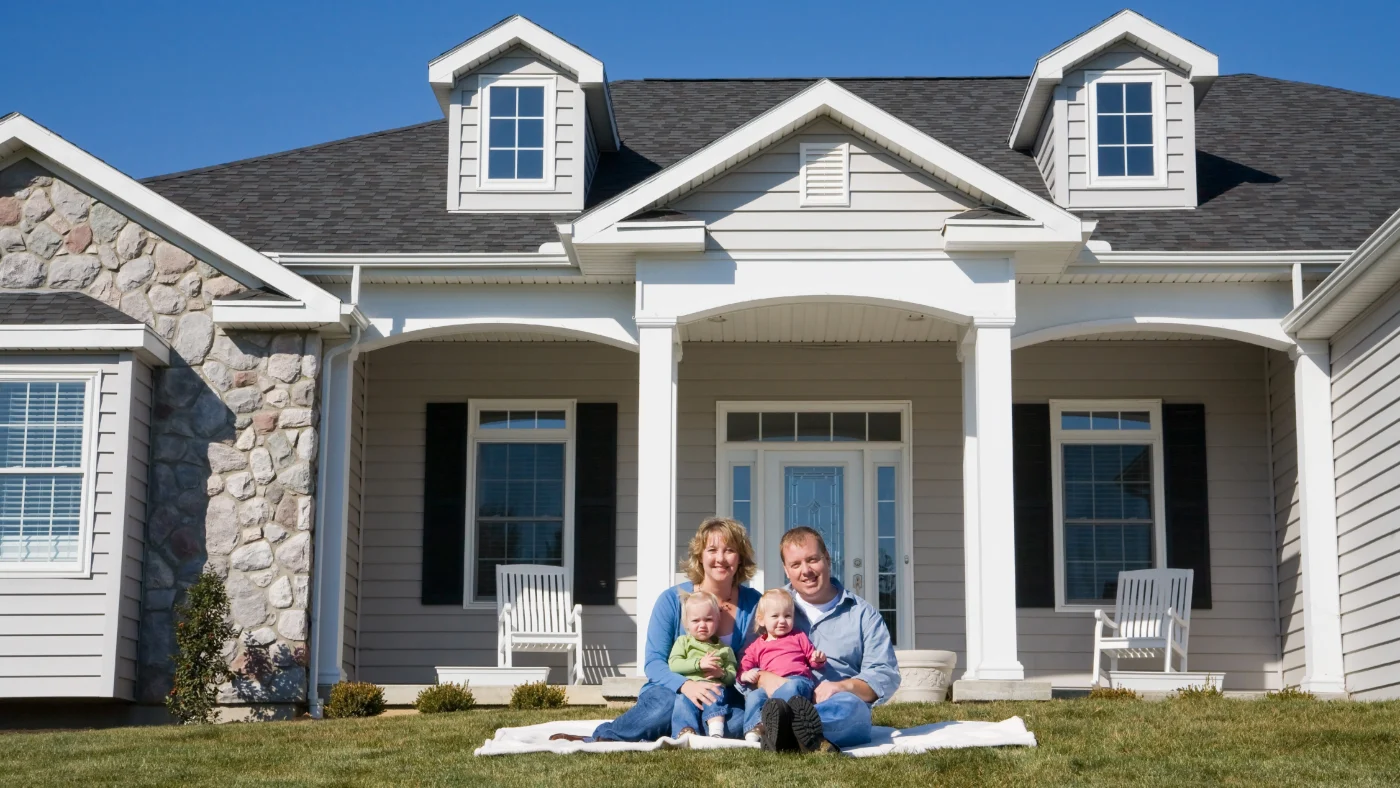 Absolute Professionalism | Universal Roof & Contracting A happy family sits in front of their home with a newly installed roof in Central Florida | Universal Roof & Contracting