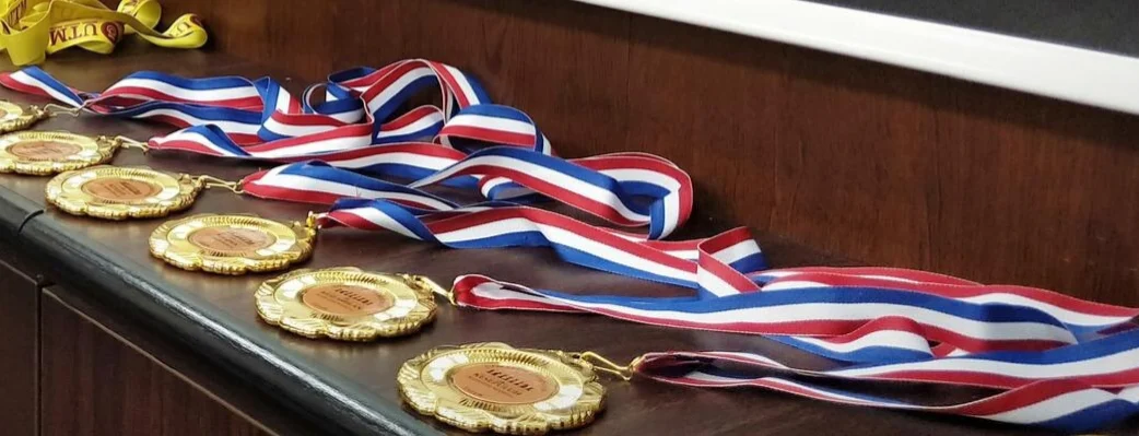 Close-up image of gold medals on a brown counter