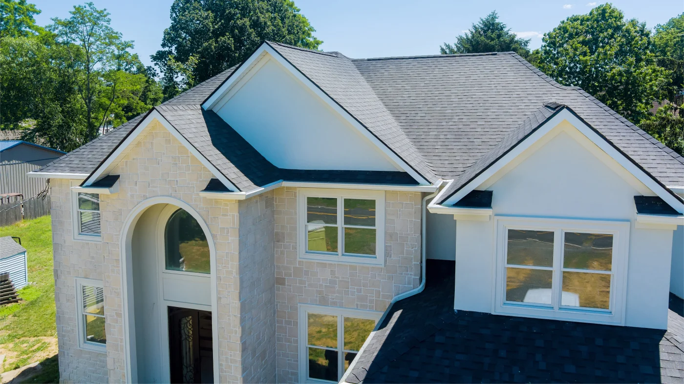 Beautiful large home exterior with gray siding and well-kept asphalt shingle roof