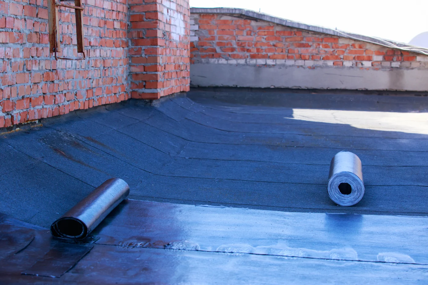 Image of roofing material on the roof of a brick building