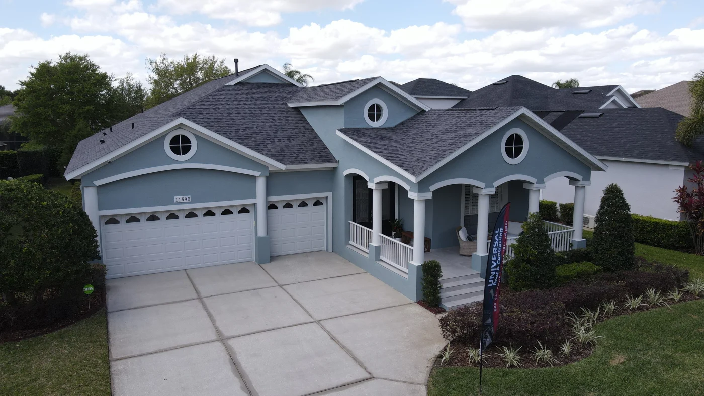 A home with blue exterior paint and a newly installed gray asphalt shingle roof