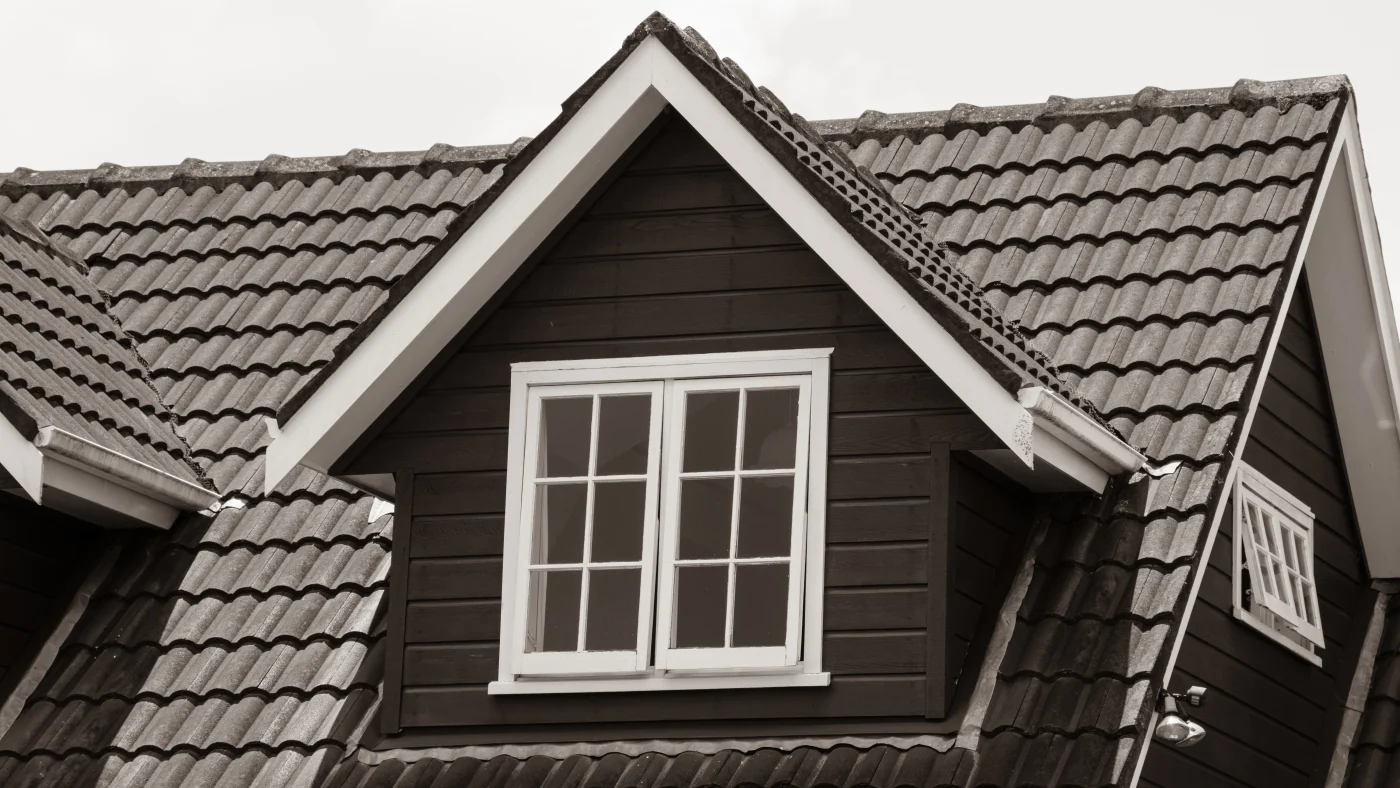 Closeup of a brown tile roof with dormer windows