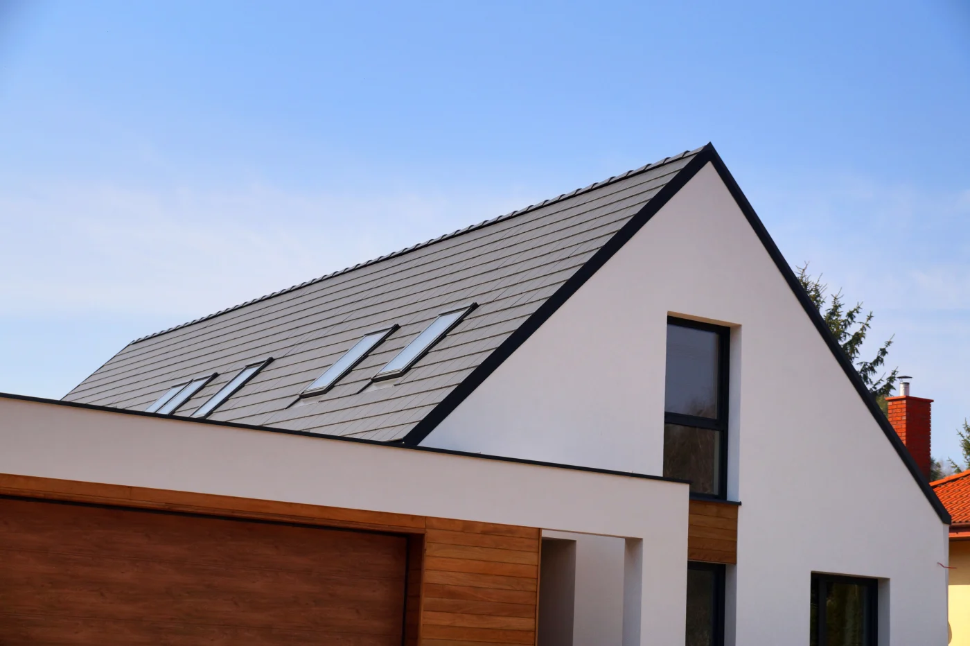 White a-frame home with dark metal roof