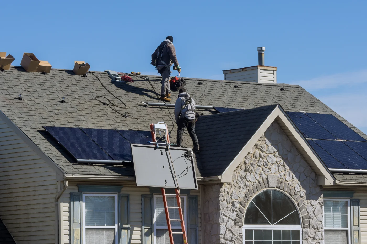 Expert roof repair on a large house with solar panels