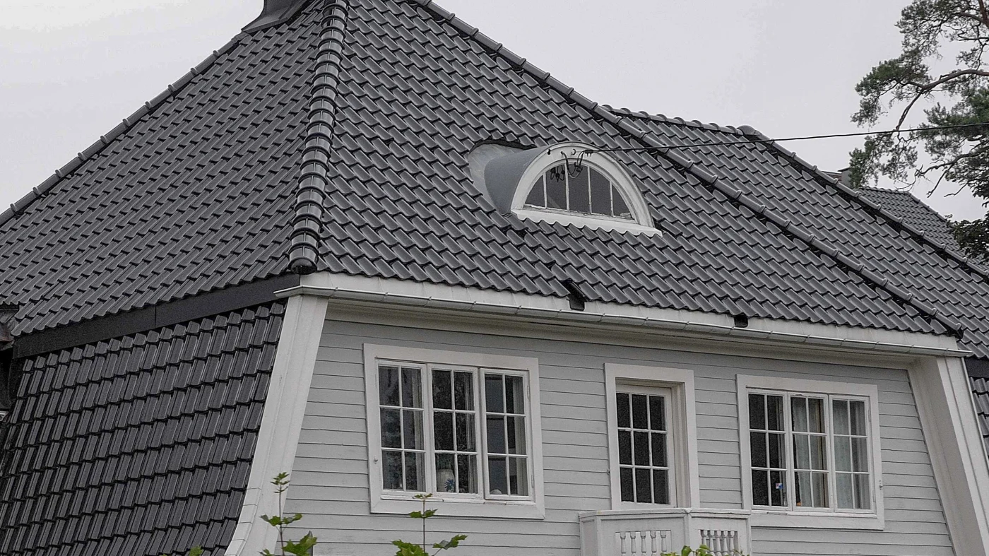Bright red tile roof with two skylights and roof vents on it