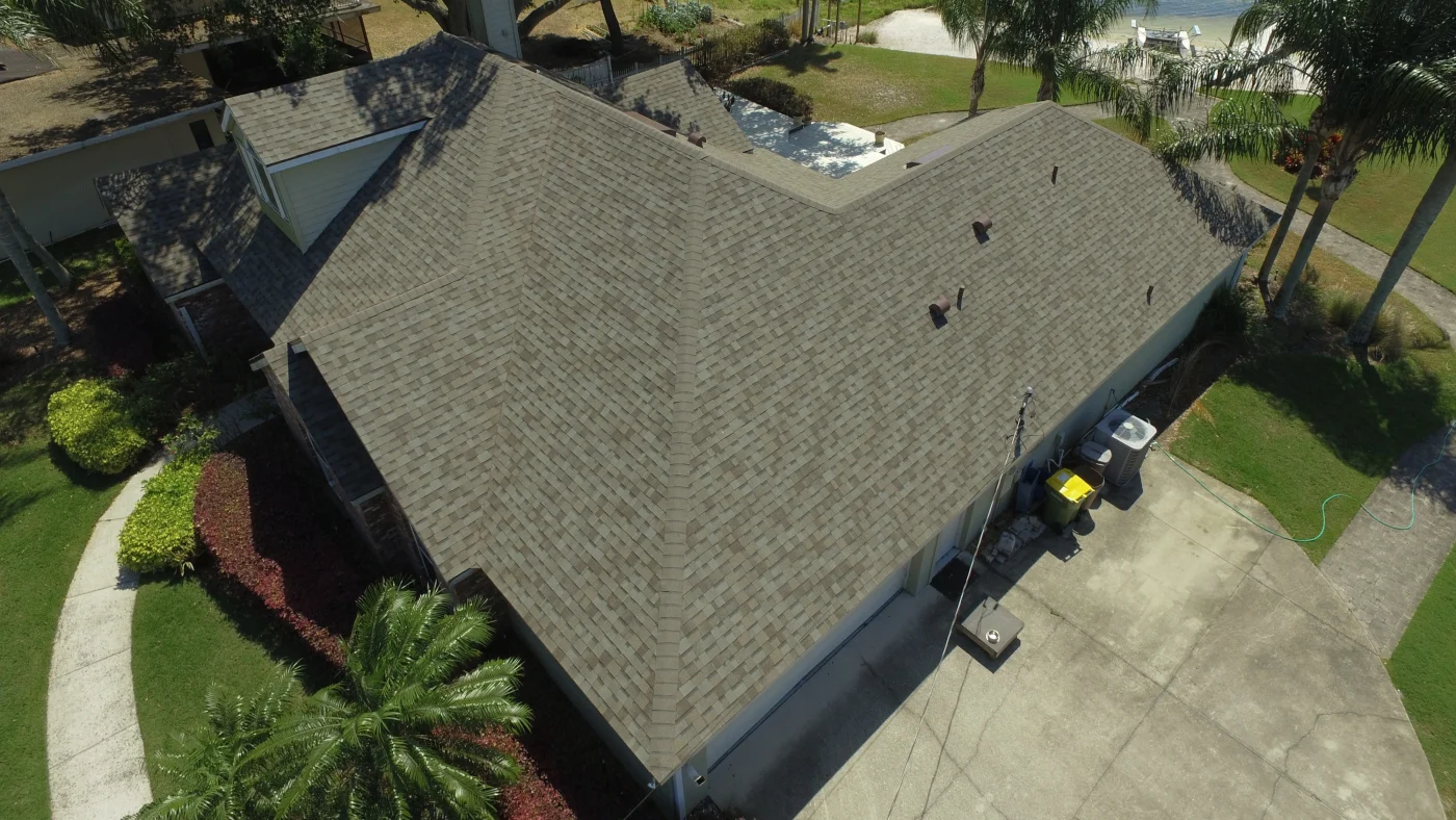 Drone shot of newly installed dark asphalt shingle roof on large Tampa home