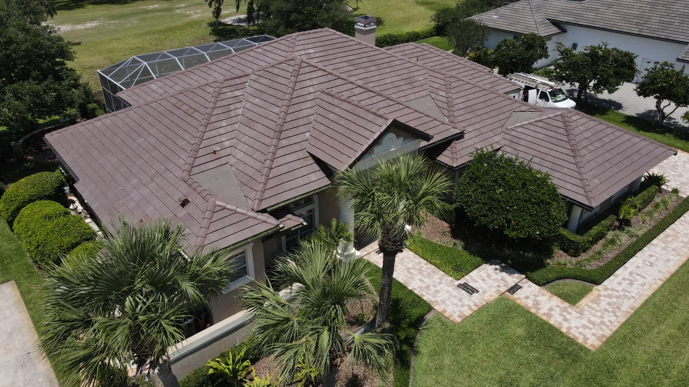 A unique geometric metal tile roof replacement by Universal Roof and Contracting on a white and brown estate home in Central Florida.