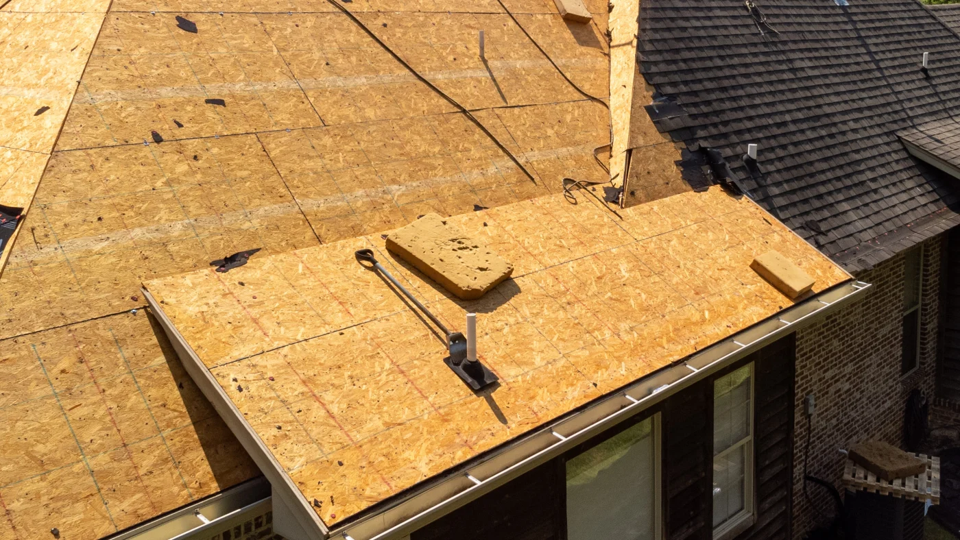 A residential roof in mid-tear-off