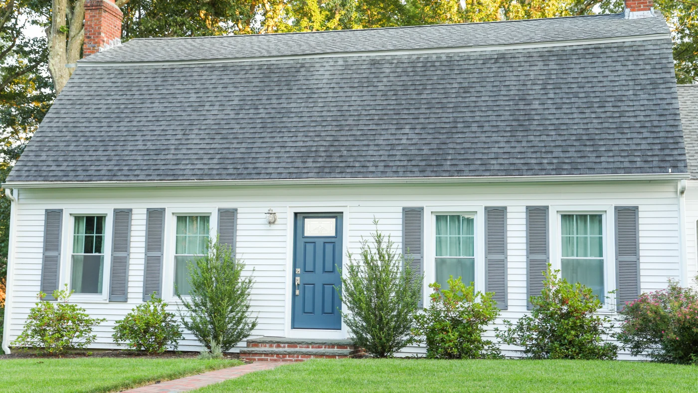 Home with large asphalt roofing and white siding