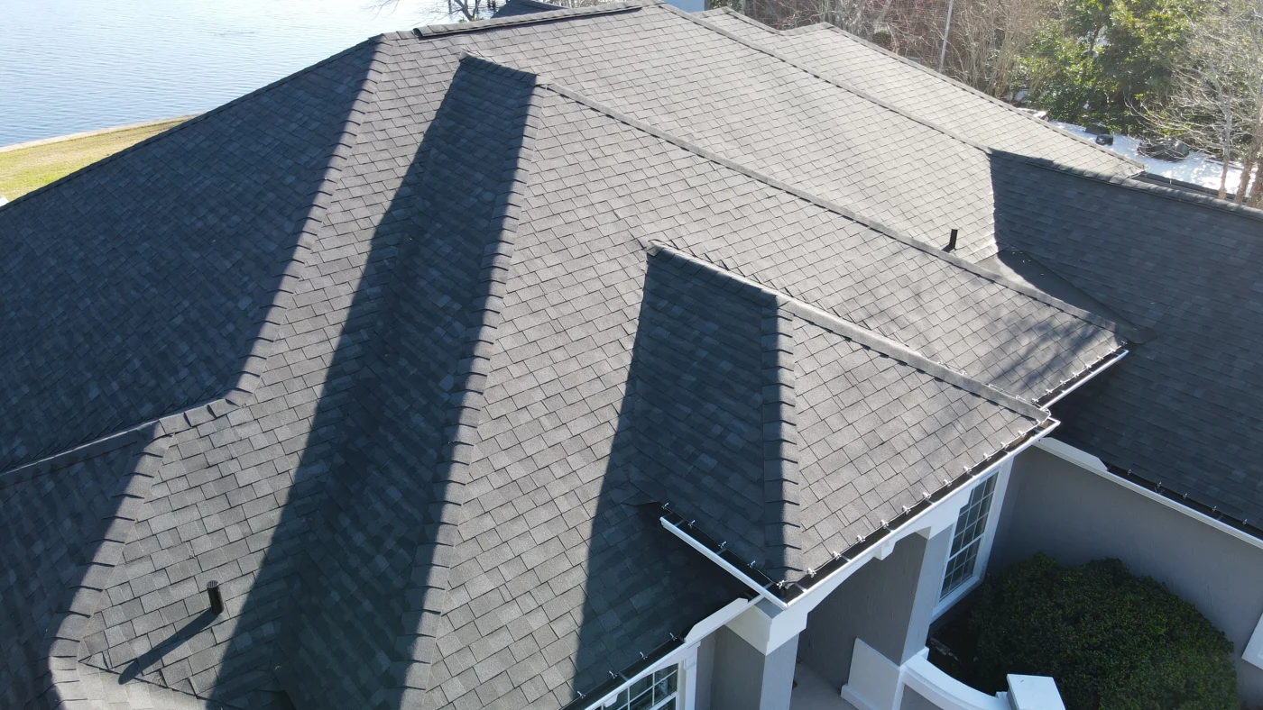 Large commercial metal roof with a cloudy sky background