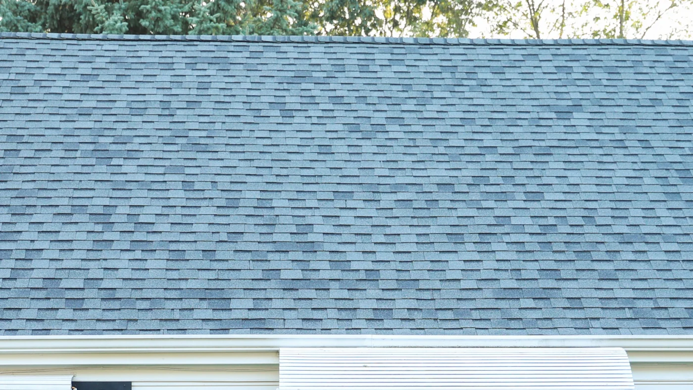 Home with large elaborate blue roof and tan siding