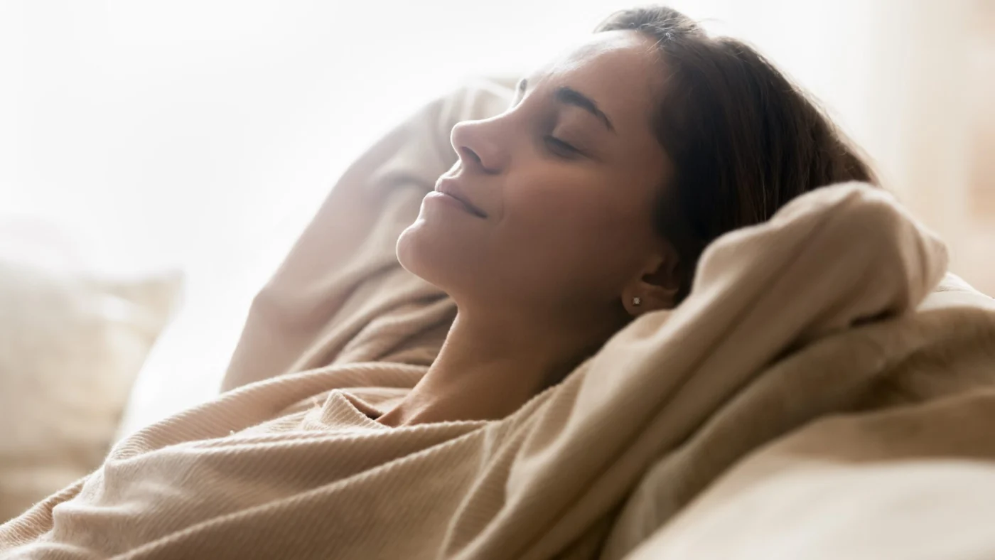 Happy Young Woman Relaxing On Comfortable Sofa At Home Happy Young Woman Relaxing On Comfortable Sofa At Home