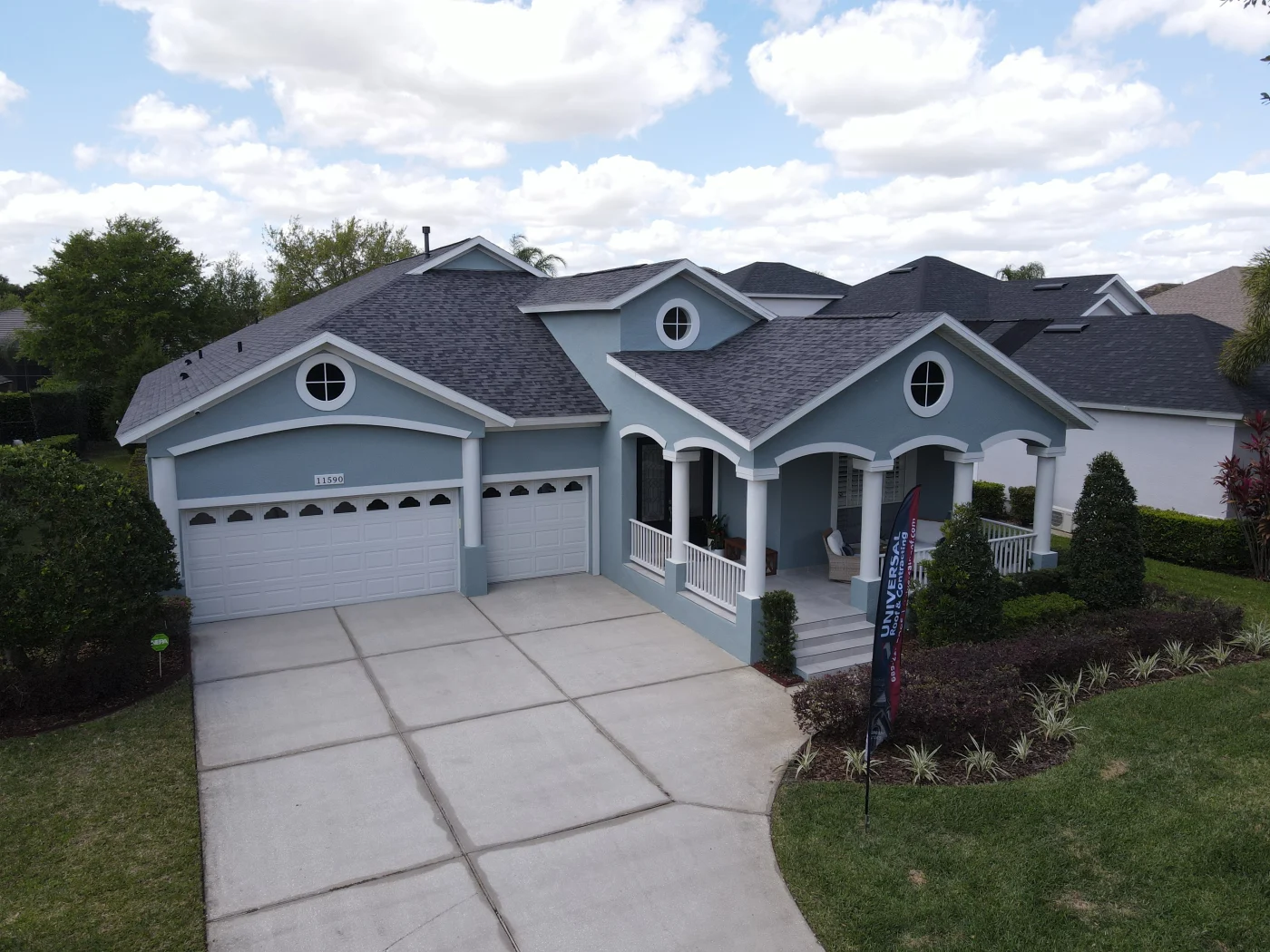 Dark gray asphalt roof on light blue home