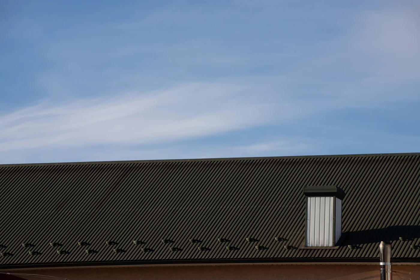 This image features a close-up of a commercial building’s metal roof.
