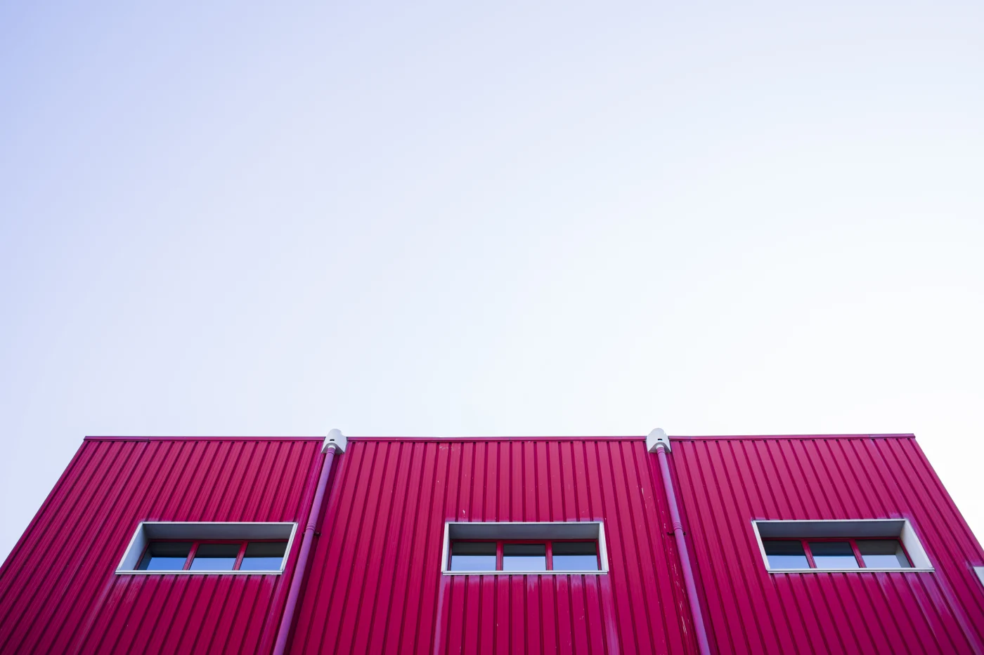 This image features a commercial building with a red metal roof.