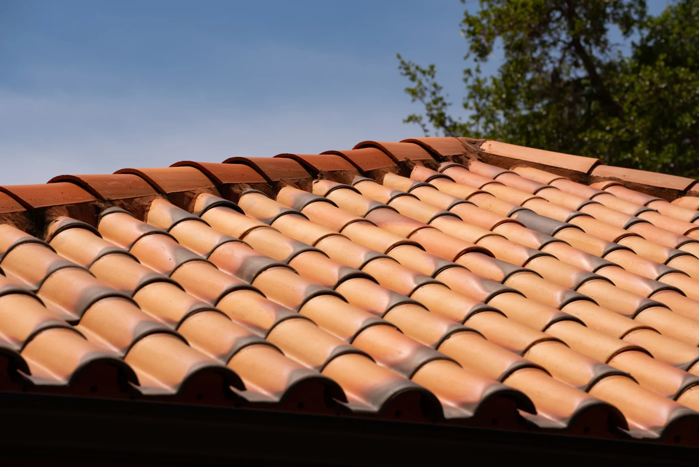 A close-up of red clay Spanish tile roofing with a rugged, long-lasting finish.