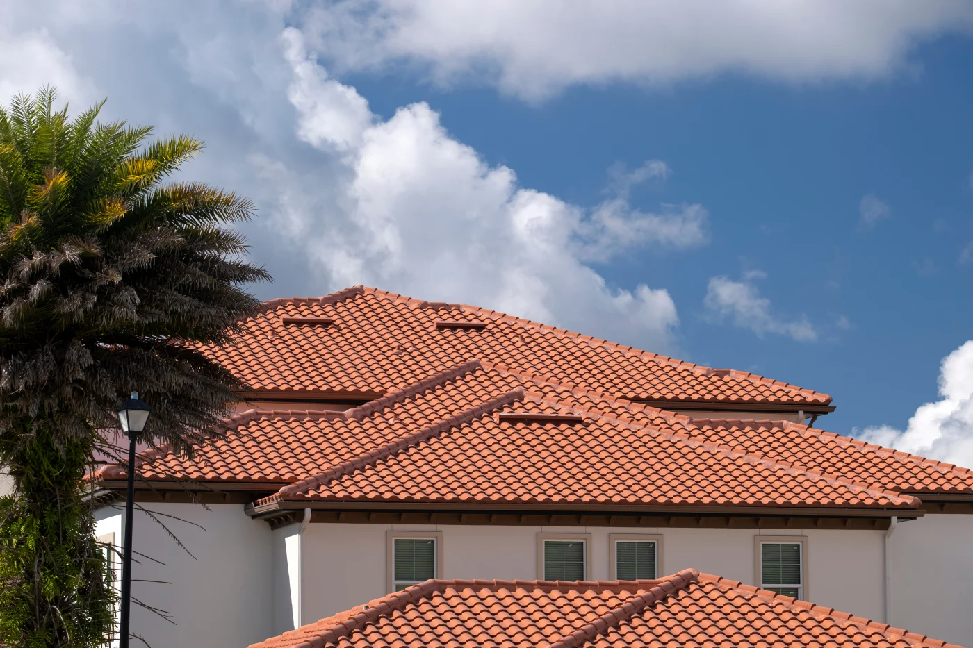 Closeup Of House Rooftop Covered With Ceramic Shingles. Tiled Covering Of Building A Mediterranean-style home in Windermere, FL, features a stunning clay tile roof