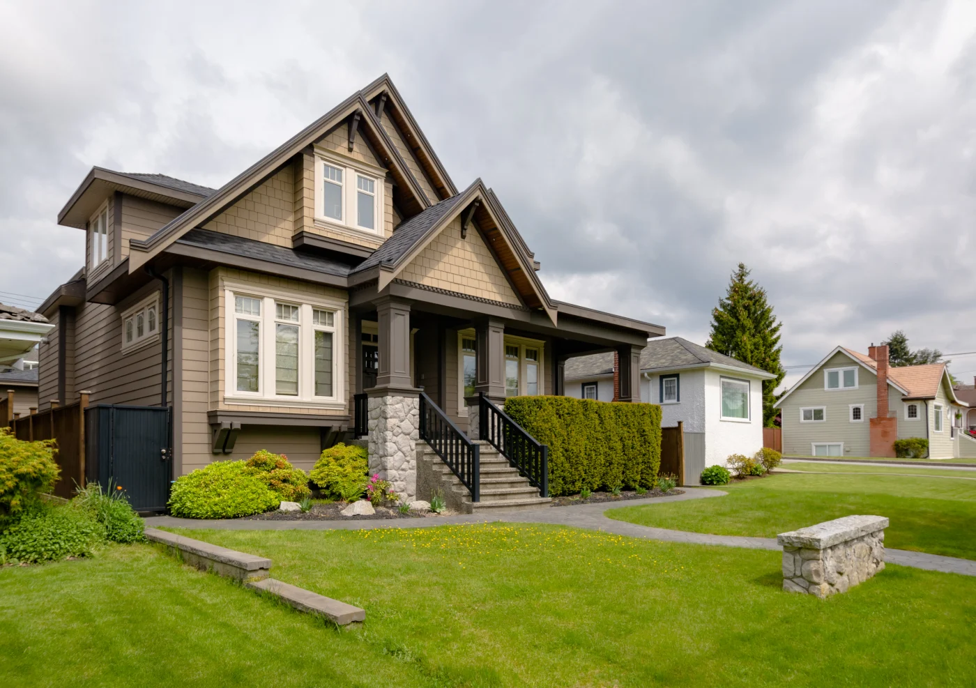 A corner view of a brown house with steps leading to the front door.