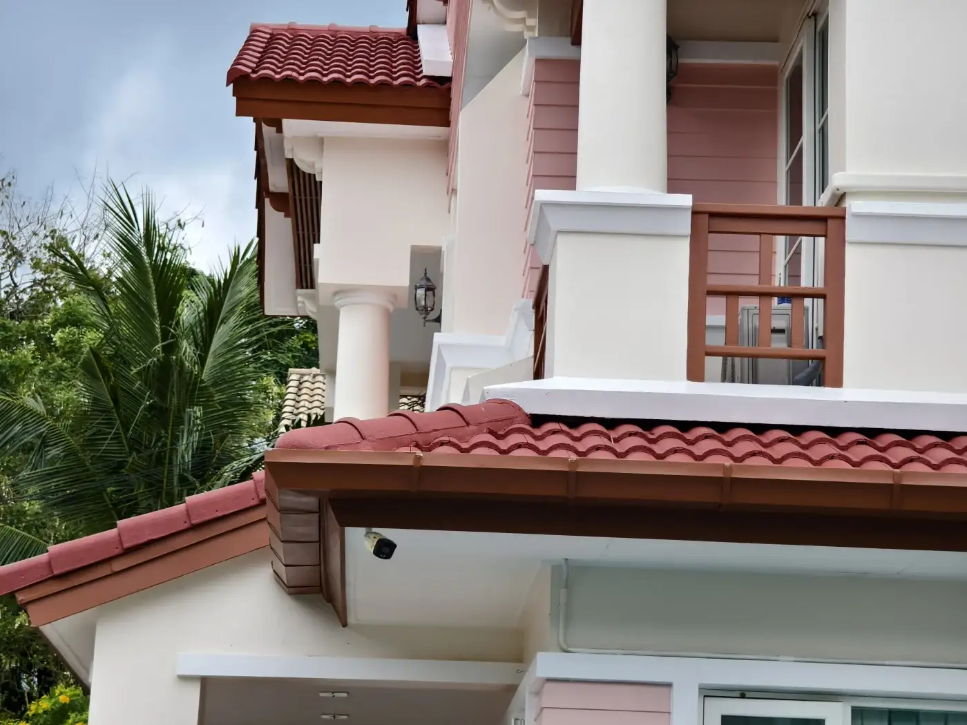 A mustard yellow house with natural clay tile roofing.
