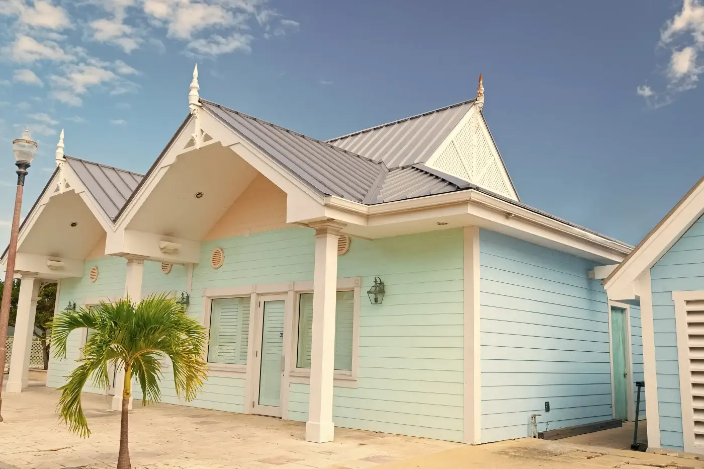 A row of pale yellow beach houses with black metal roofs installed.