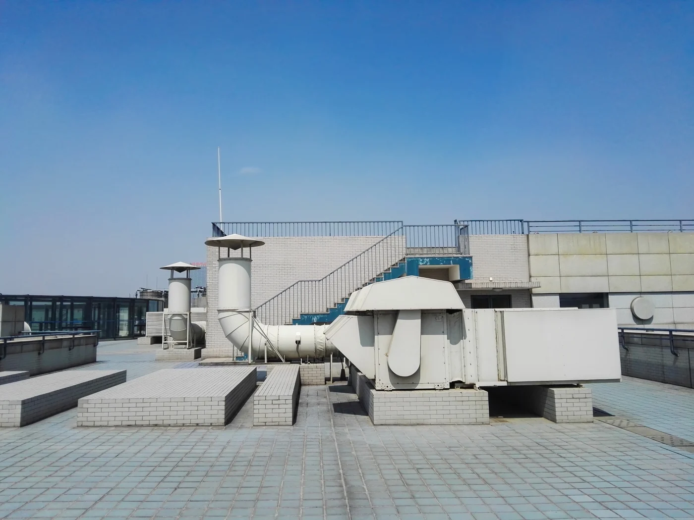 Incredible Commercial Roofing | Ponte Vedra Beach, FL | Universal Roof and Contracting A wide-angle view of a commercial rooftop with a flat, sand-colored surface overlooking a modern city skyline filled with tall buildings.